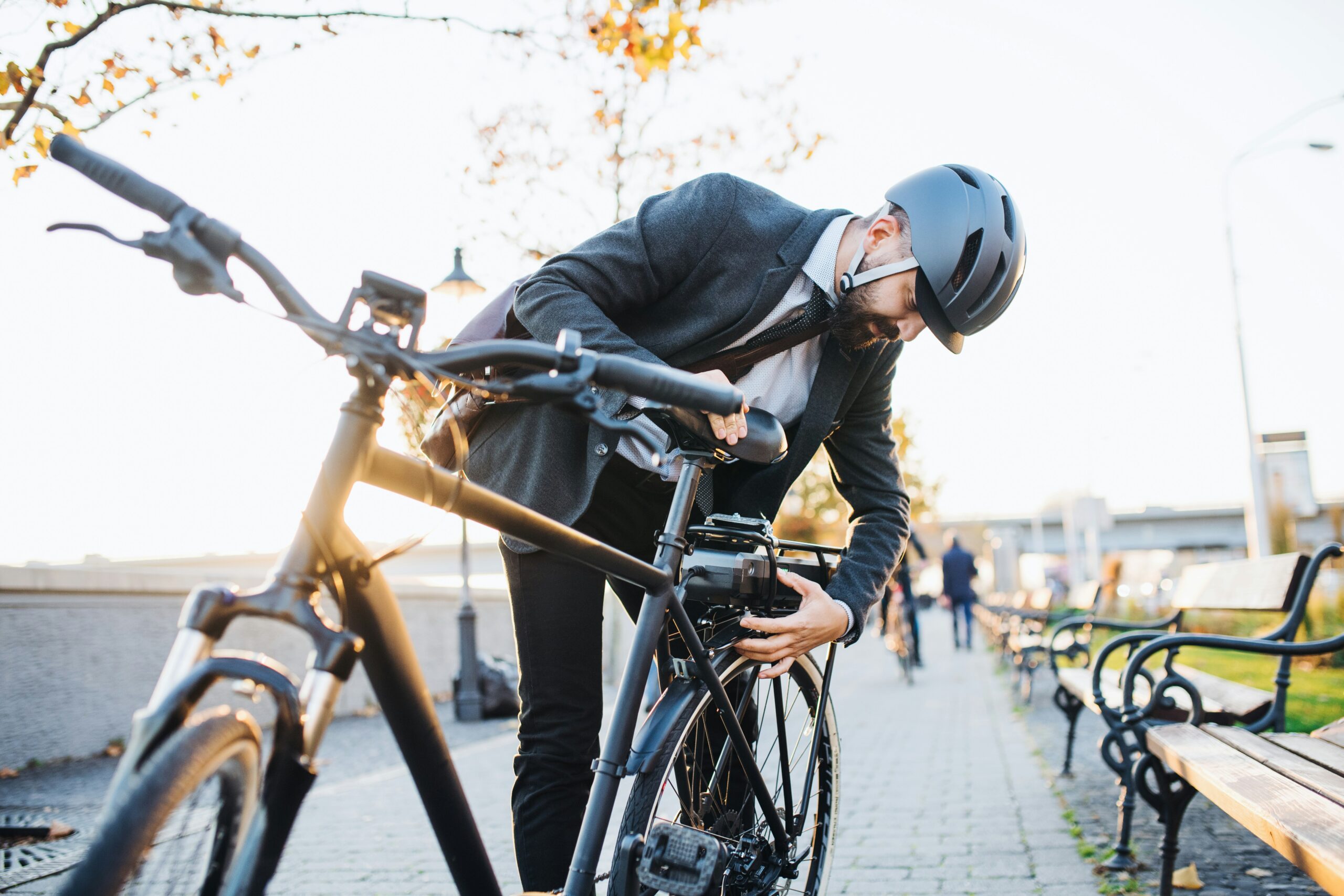 man pausing to check his bike while cycling to work