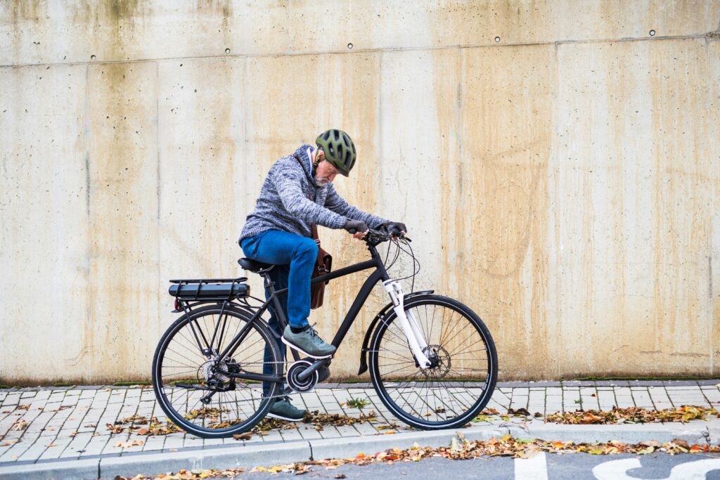 cyclist wearing a safety helmet pausing to check his bike